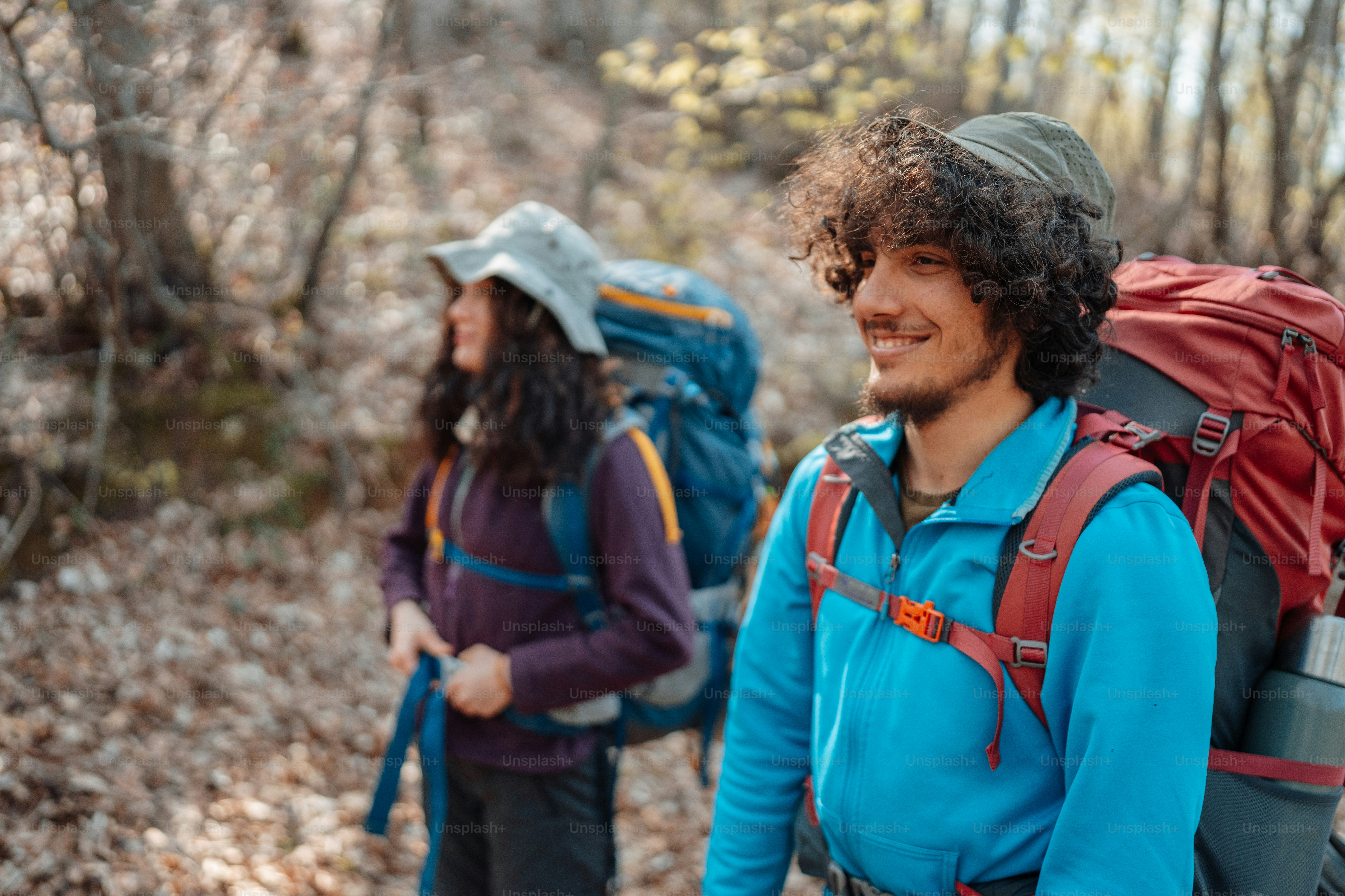 a couple of people with backpacks walking through the woods