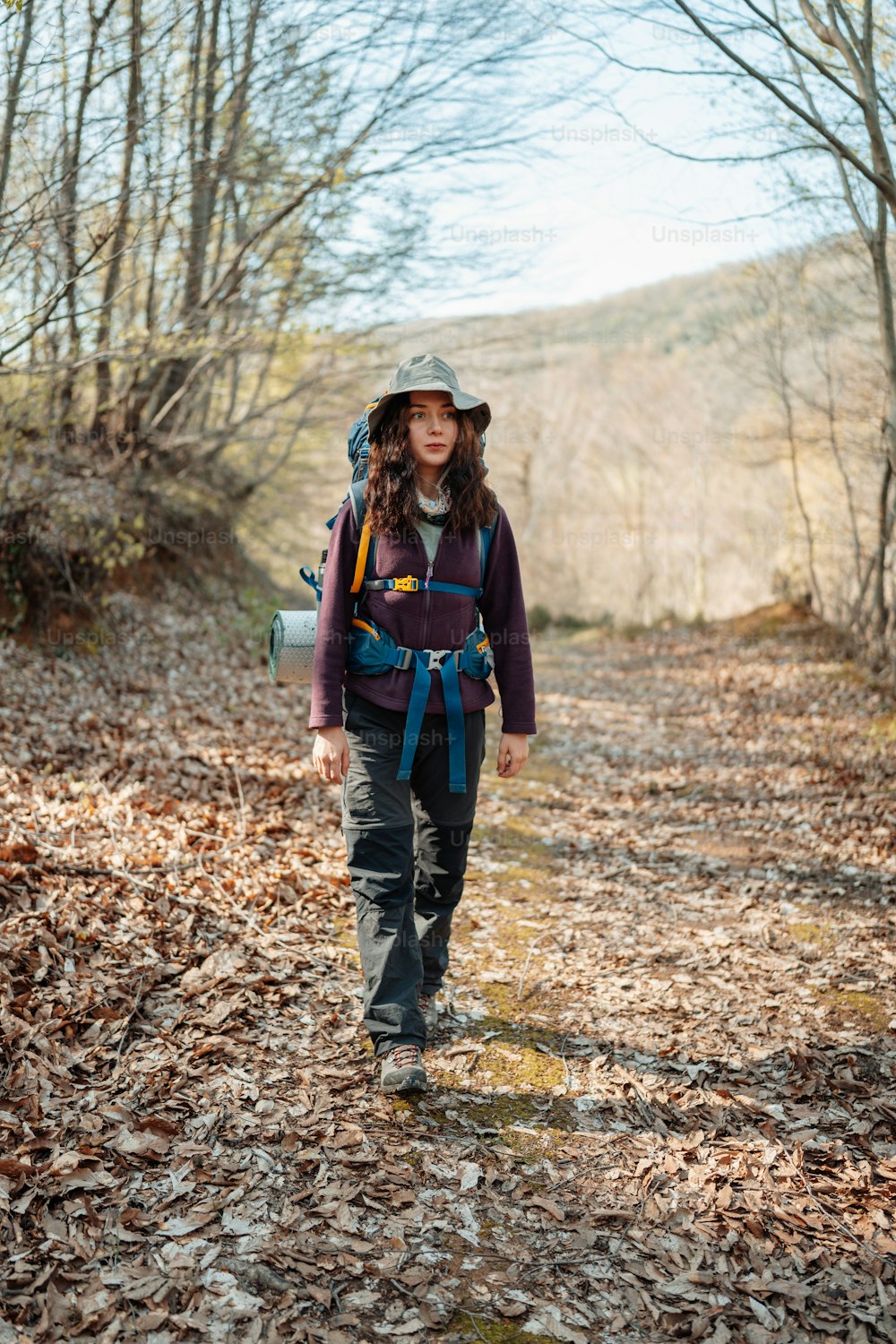 Eine Frau mit einem Rucksack geht im Wald spazieren