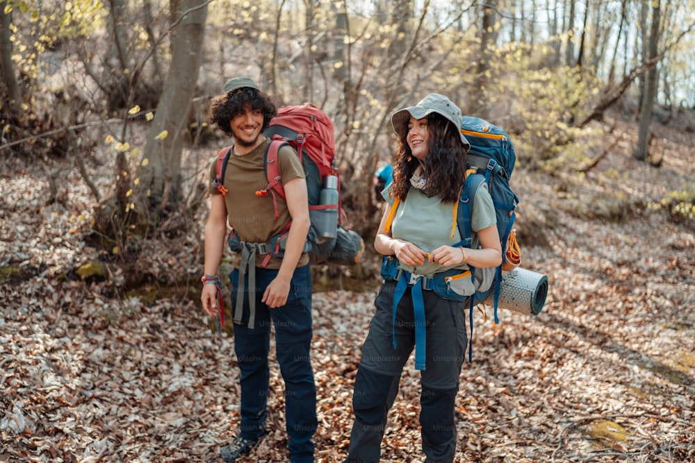 a couple of people with backpacks standing in the woods