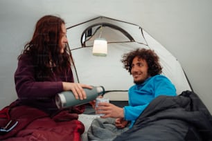 Un homme et une femme assis dans une tente