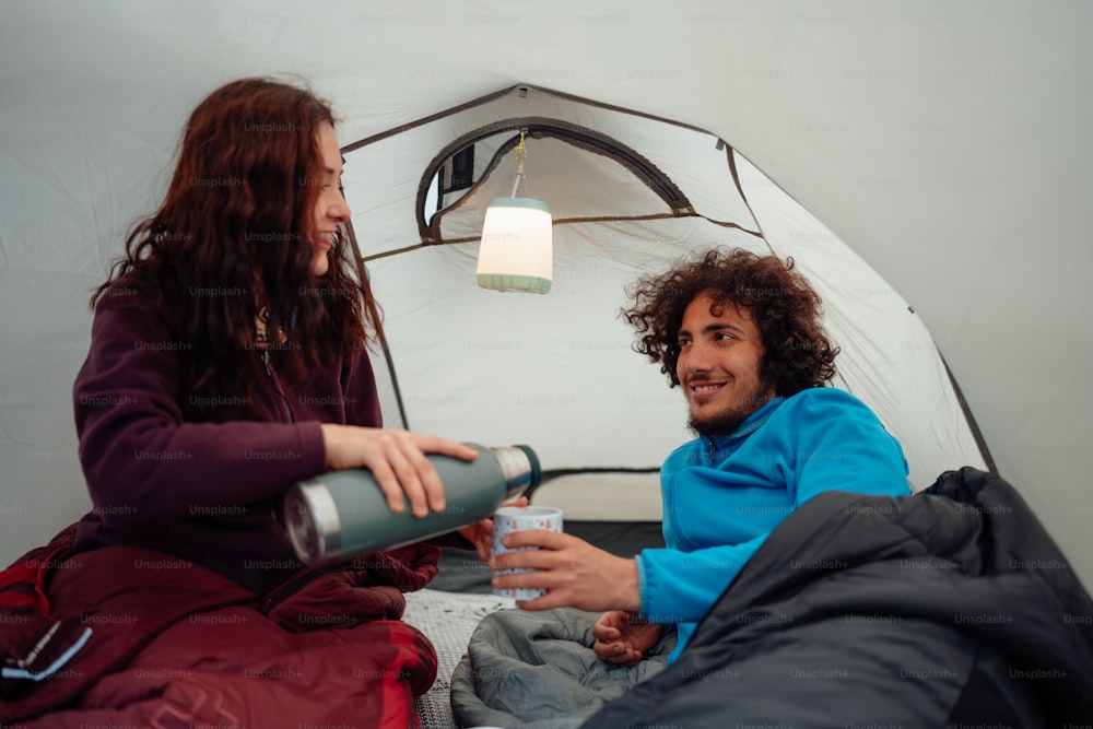 a man and a woman sitting in a tent