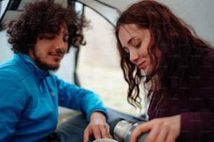 Un uomo e una donna seduti in una tenda con una tazza di caffè