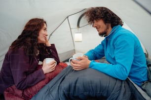 um homem e uma mulher sentados em uma tenda