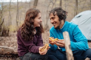 Ein Mann und eine Frau sitzen nebeneinander im Wald