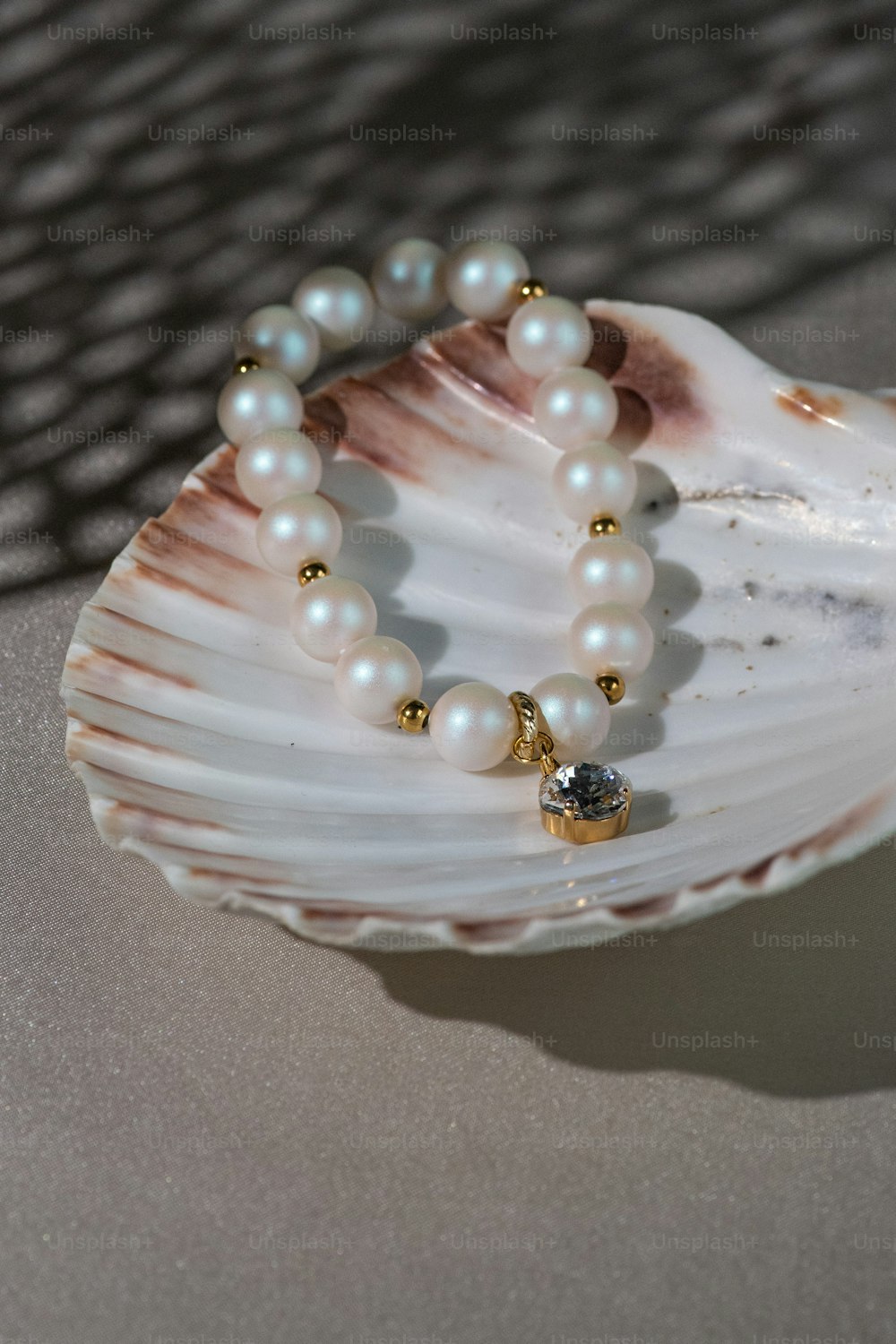 a pearl bracelet on a shell on a table