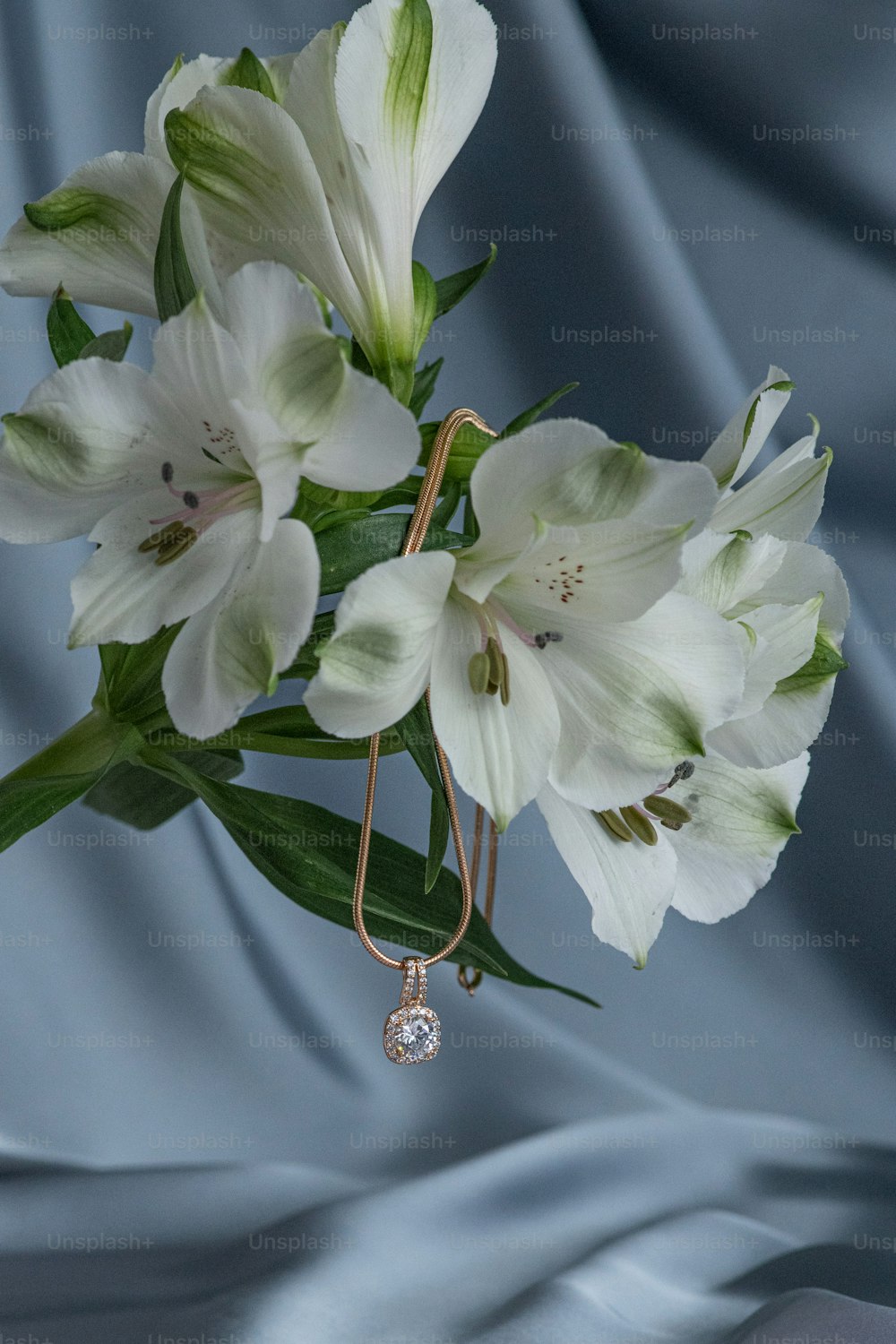 a bouquet of white flowers with a diamond hanging from it