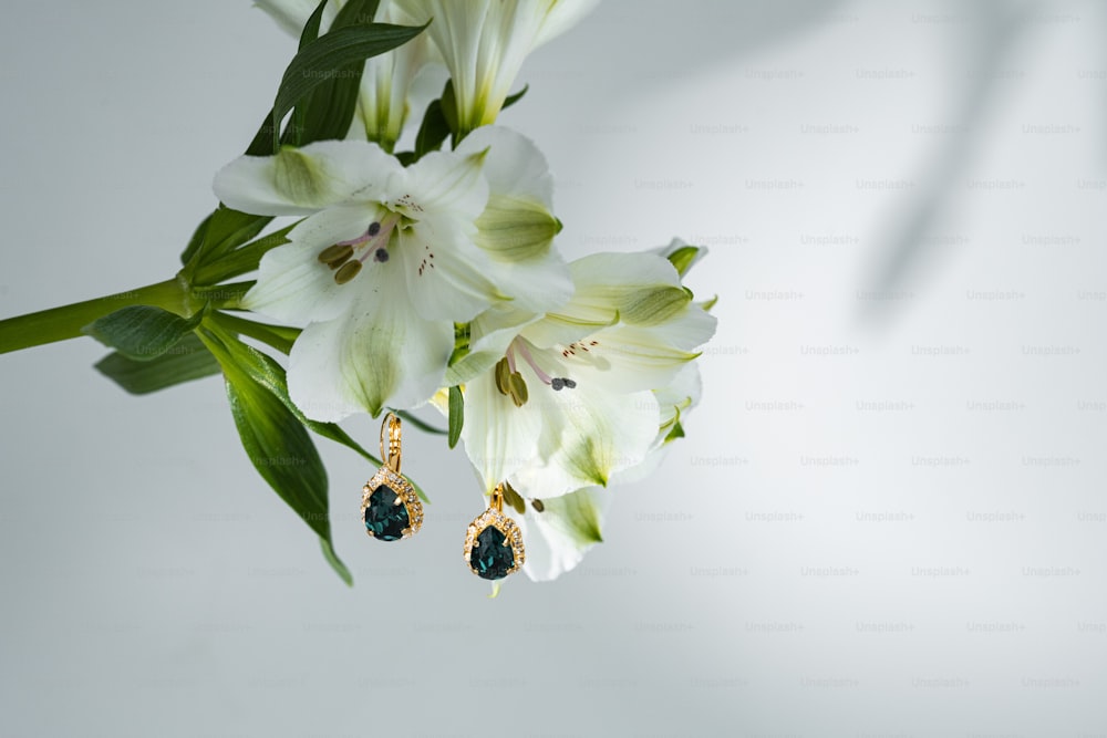 a bouquet of flowers with a pair of earrings hanging from them