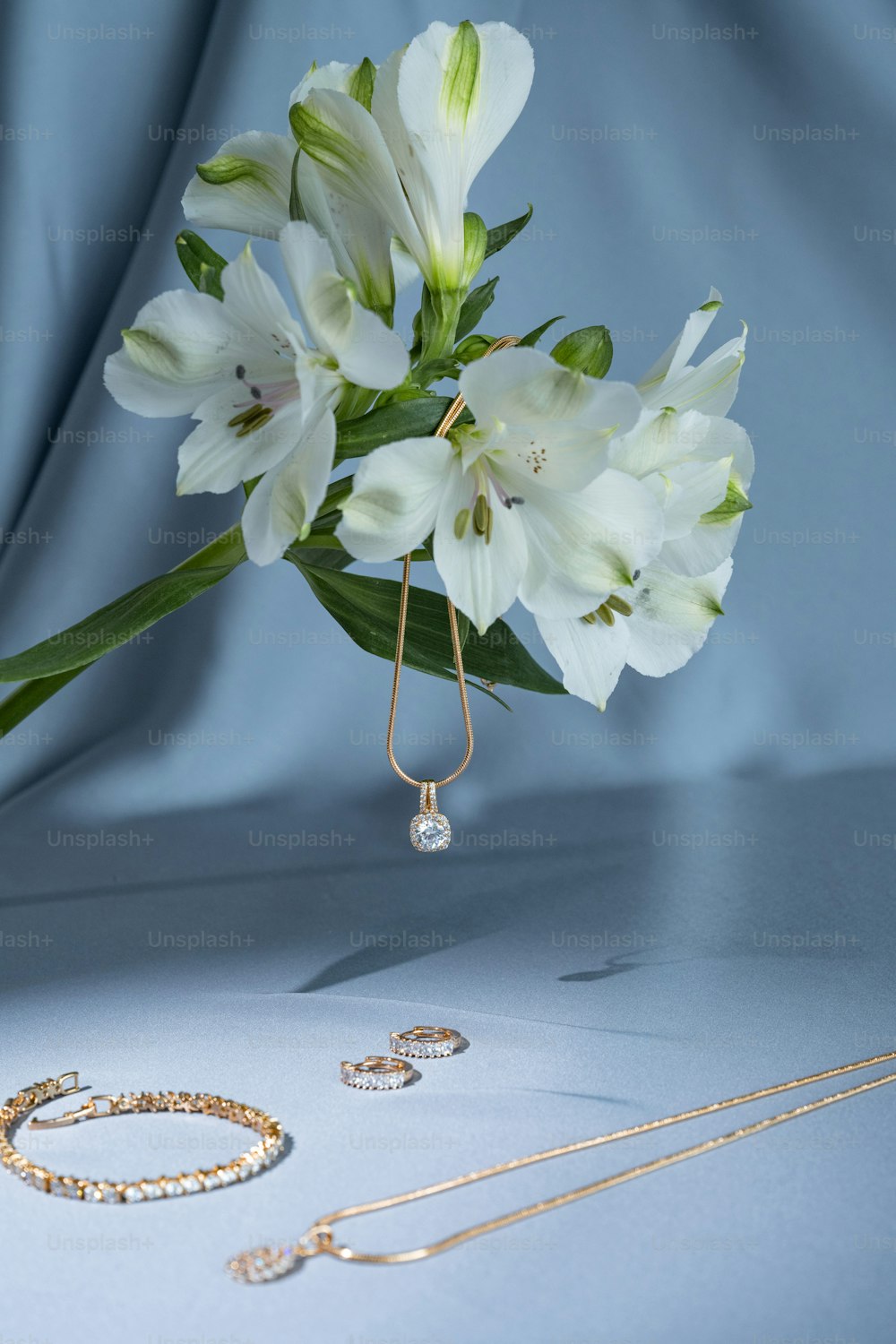 a bouquet of white flowers sitting next to a pair of earrings