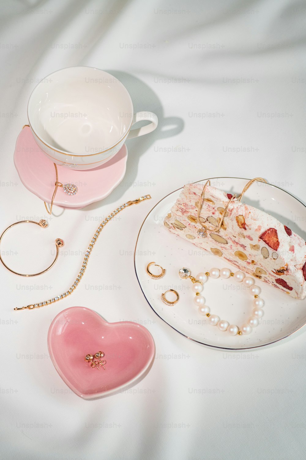 a plate with a piece of cake on it next to a pink heart - shaped