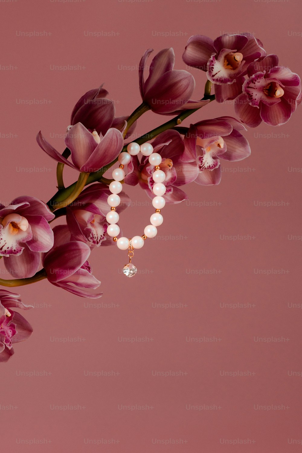 a bouquet of flowers with pearls on a pink background
