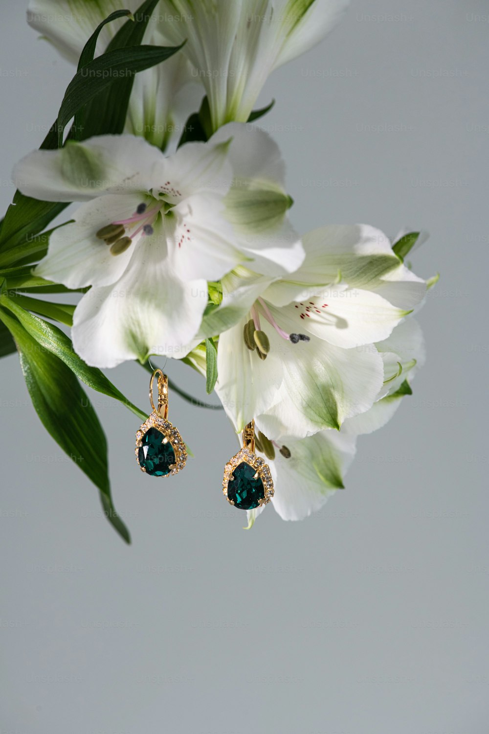 a pair of earrings sitting on top of a flower