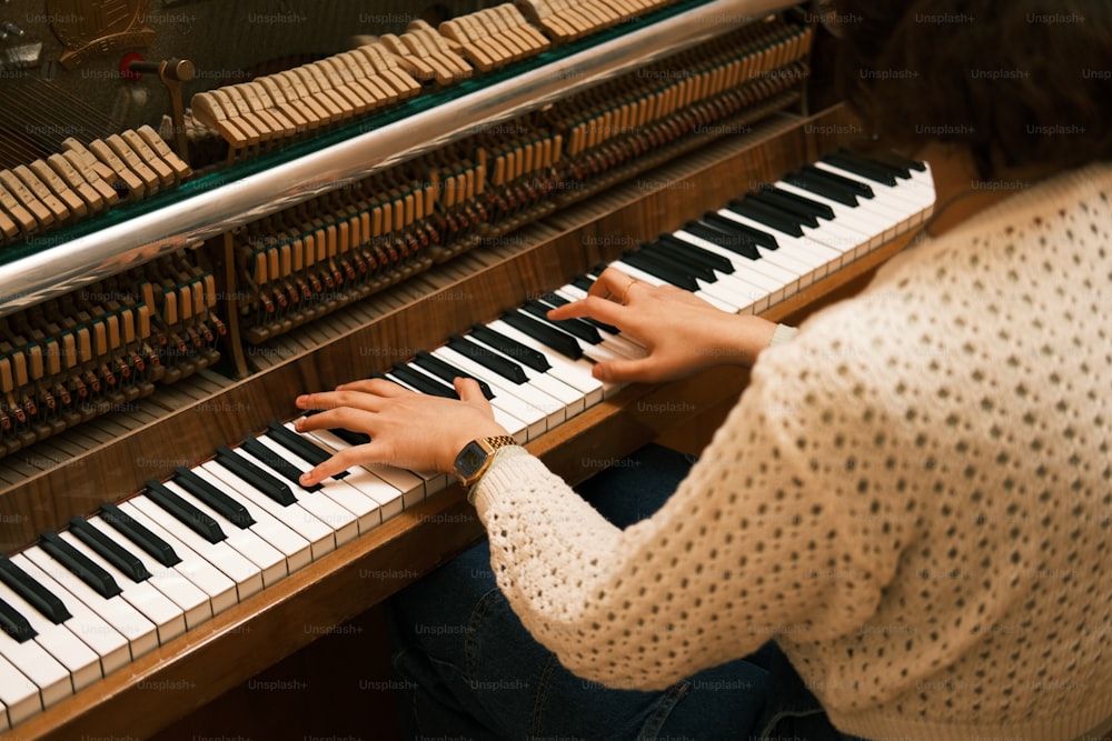 a woman sitting at a piano with her hands on the keys
