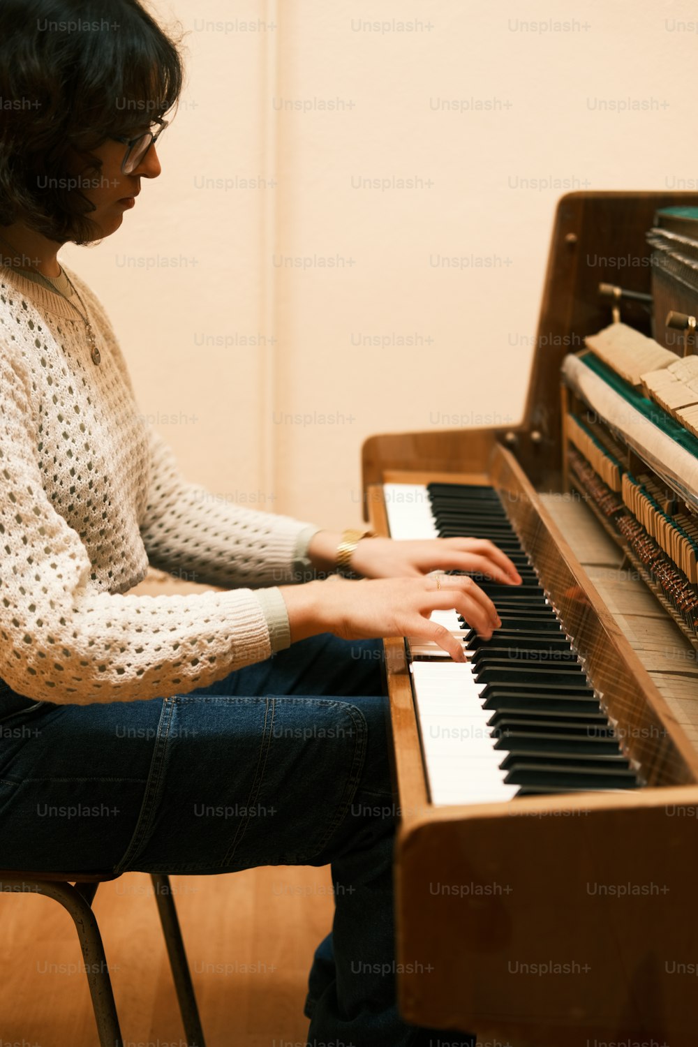 ピアノの前に座って楽器を演奏する女性