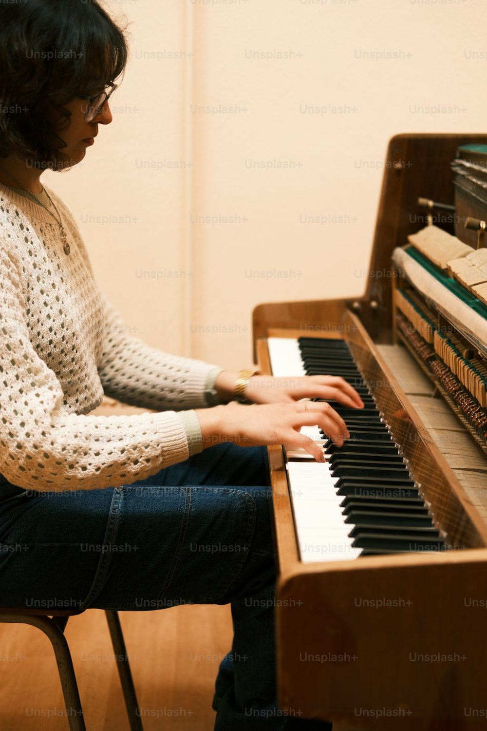 a woman sitting at a piano playing a musical instrument