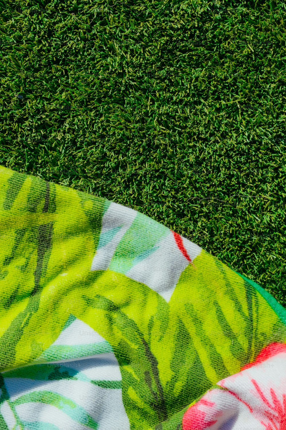 a towel laying on top of a lush green field