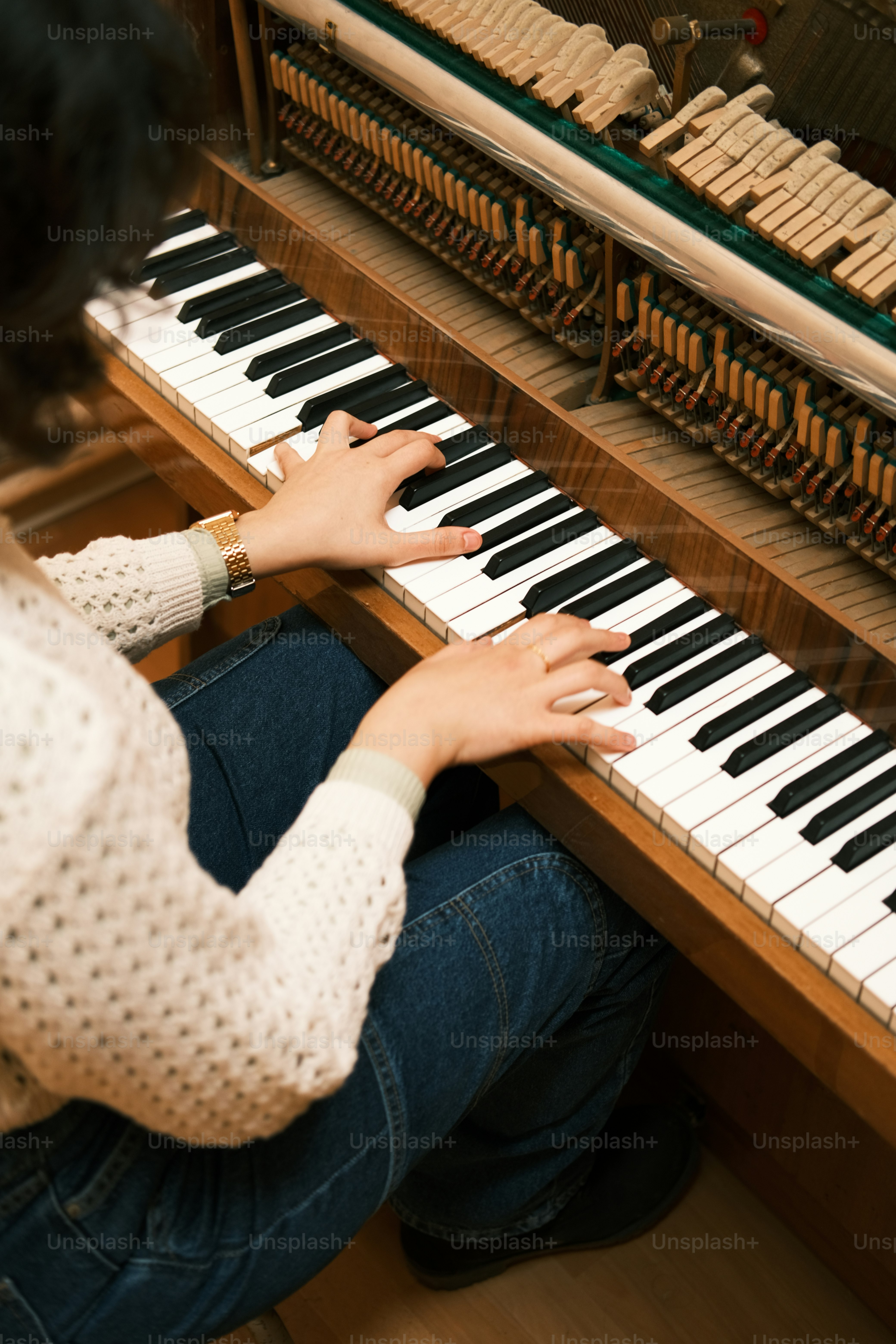 a woman sitting at a piano with her hands on the keys
