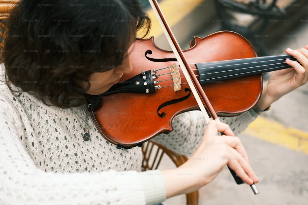 Una donna che suona un violino per strada
