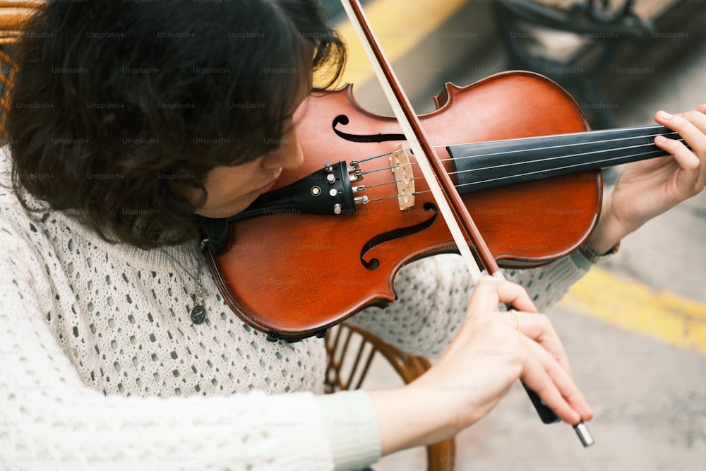 a woman playing a violin on the street