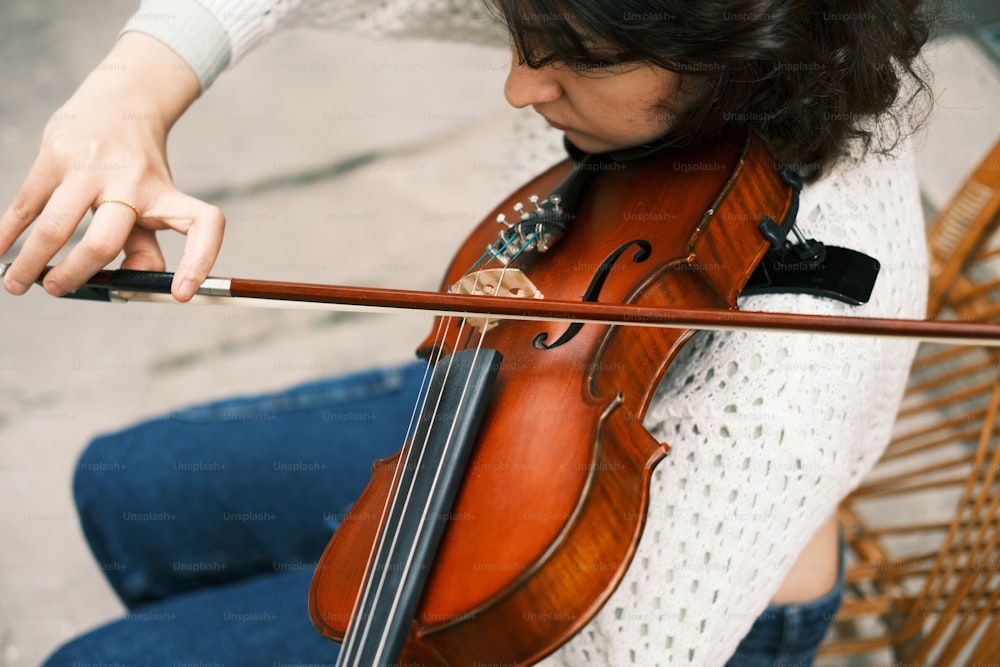 a woman playing a violin on the street