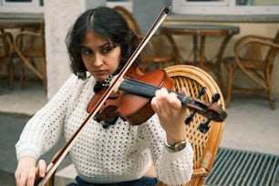 Una mujer está tocando un violín afuera