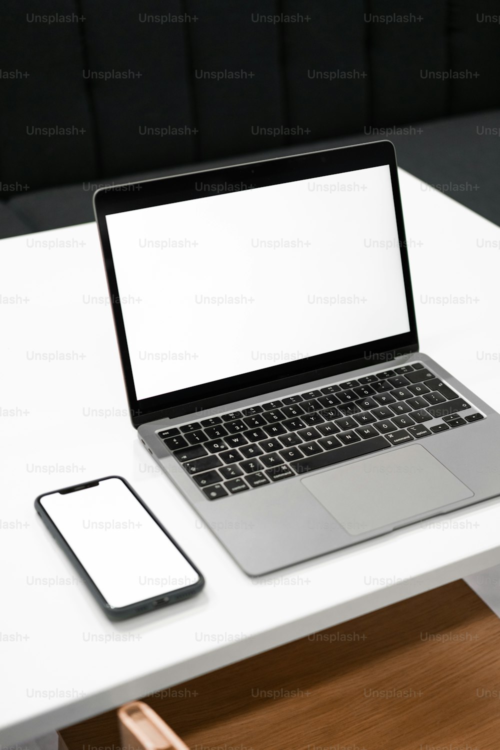 un ordinateur portable posé sur une table blanche