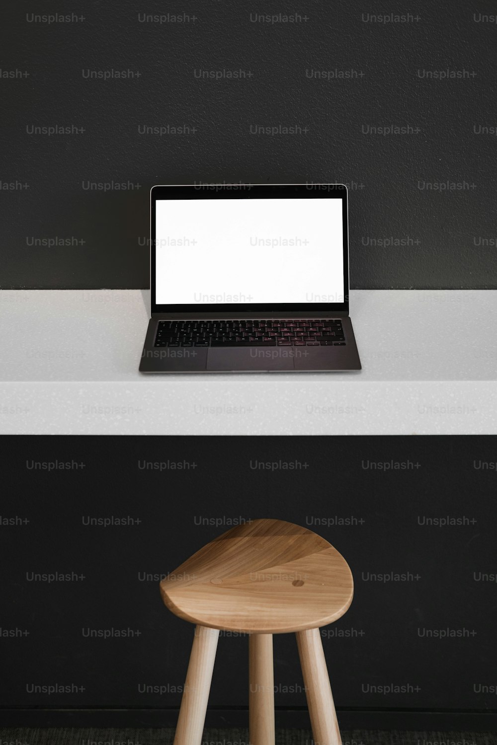 un ordinateur portable posé sur un tabouret en bois