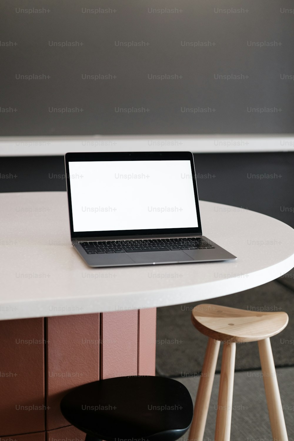 um computador portátil sentado em cima de uma mesa branca