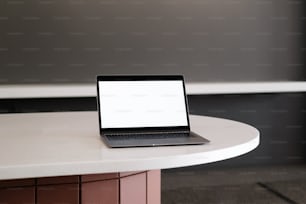 하얀 탁자 위에 앉아 있는 노트북 컴퓨터