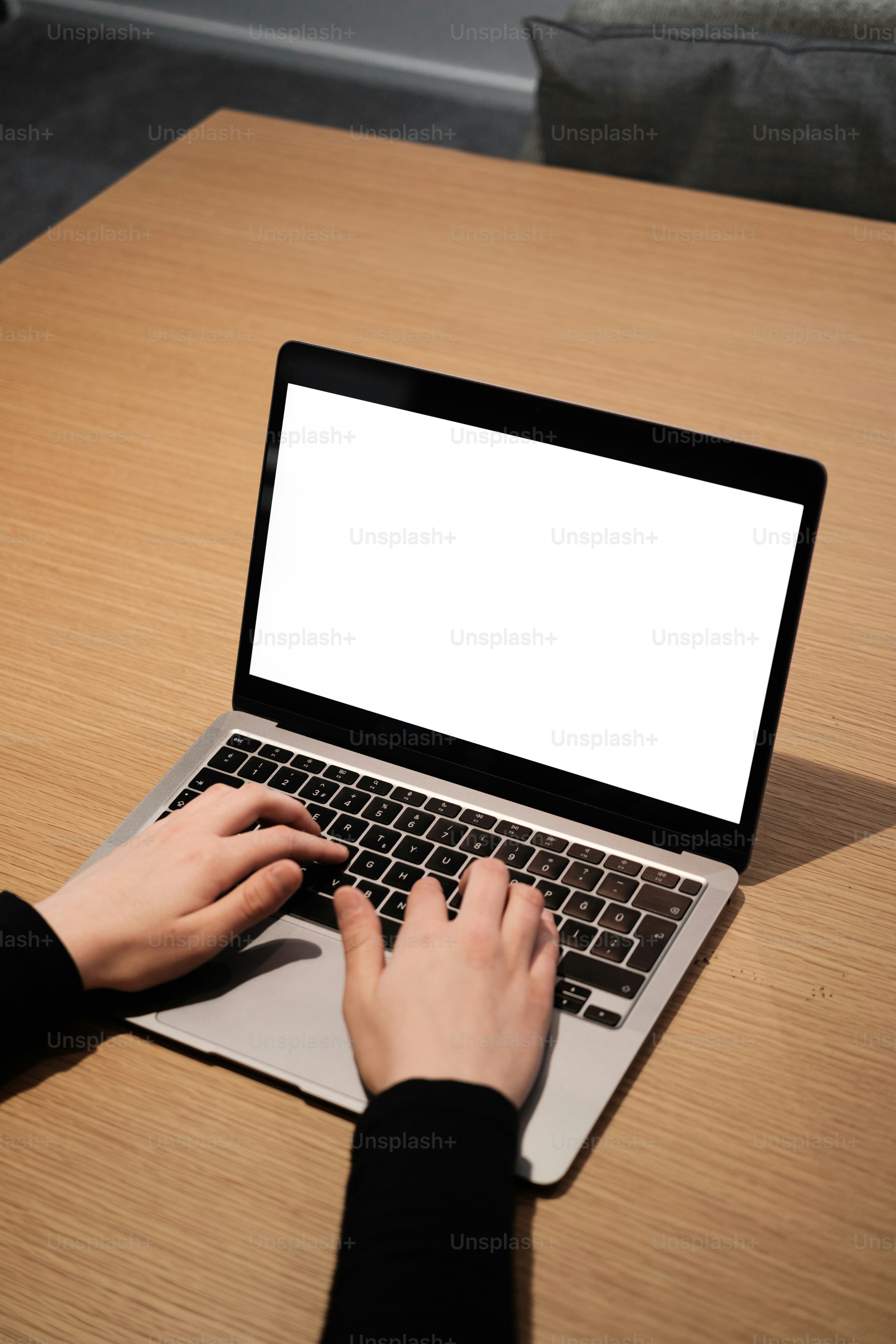 seseorang mengetik di laptop di atas meja kayu