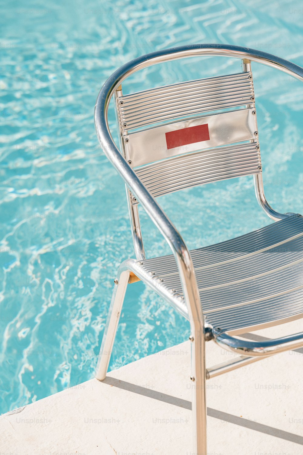 uma cadeira sentada ao lado de uma piscina