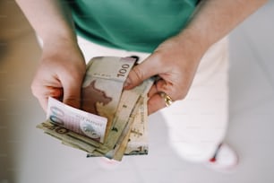 eine Person, die einen Haufen Geld in den Händen hält