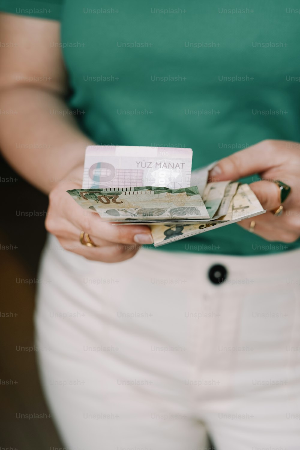 Una mujer sosteniendo una pila de dinero en sus manos