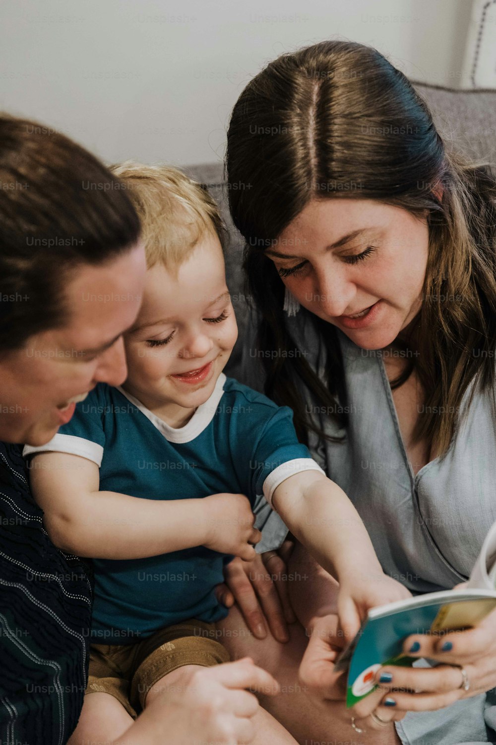 a woman sitting on a couch with two children