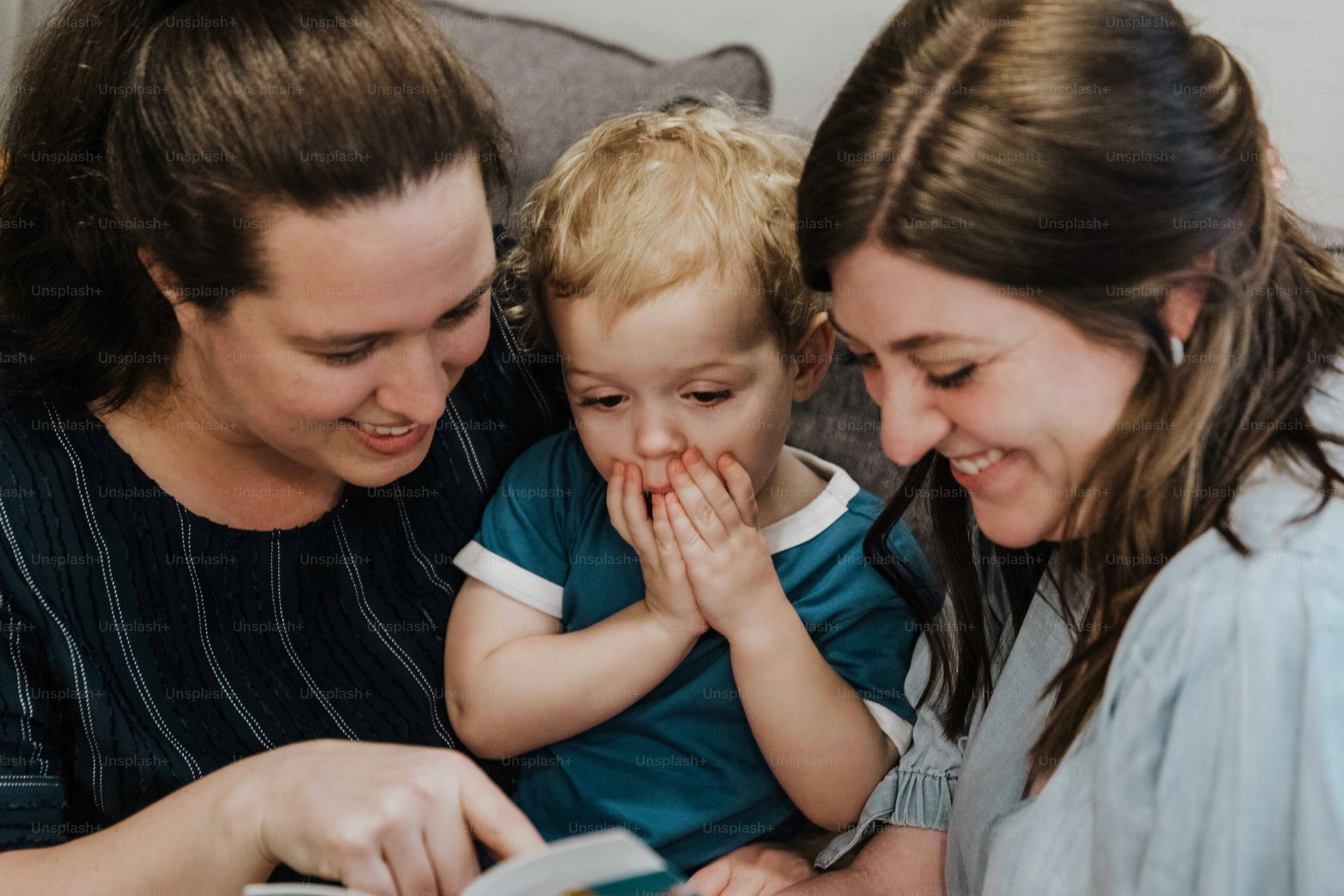 a woman and two children looking at a book