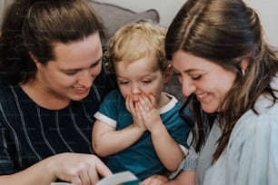 a woman and two children looking at a book