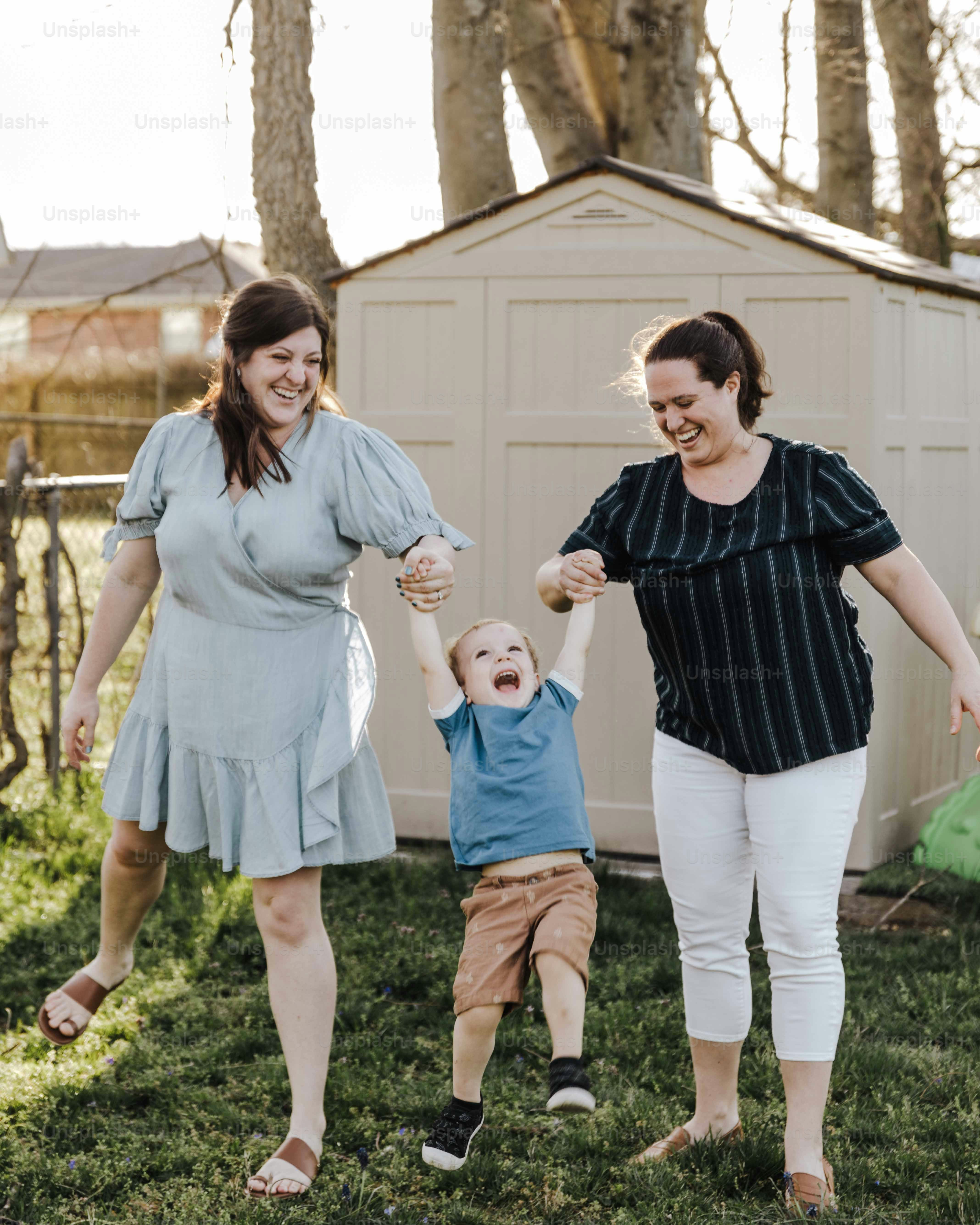 a woman and a child holding hands in a yard