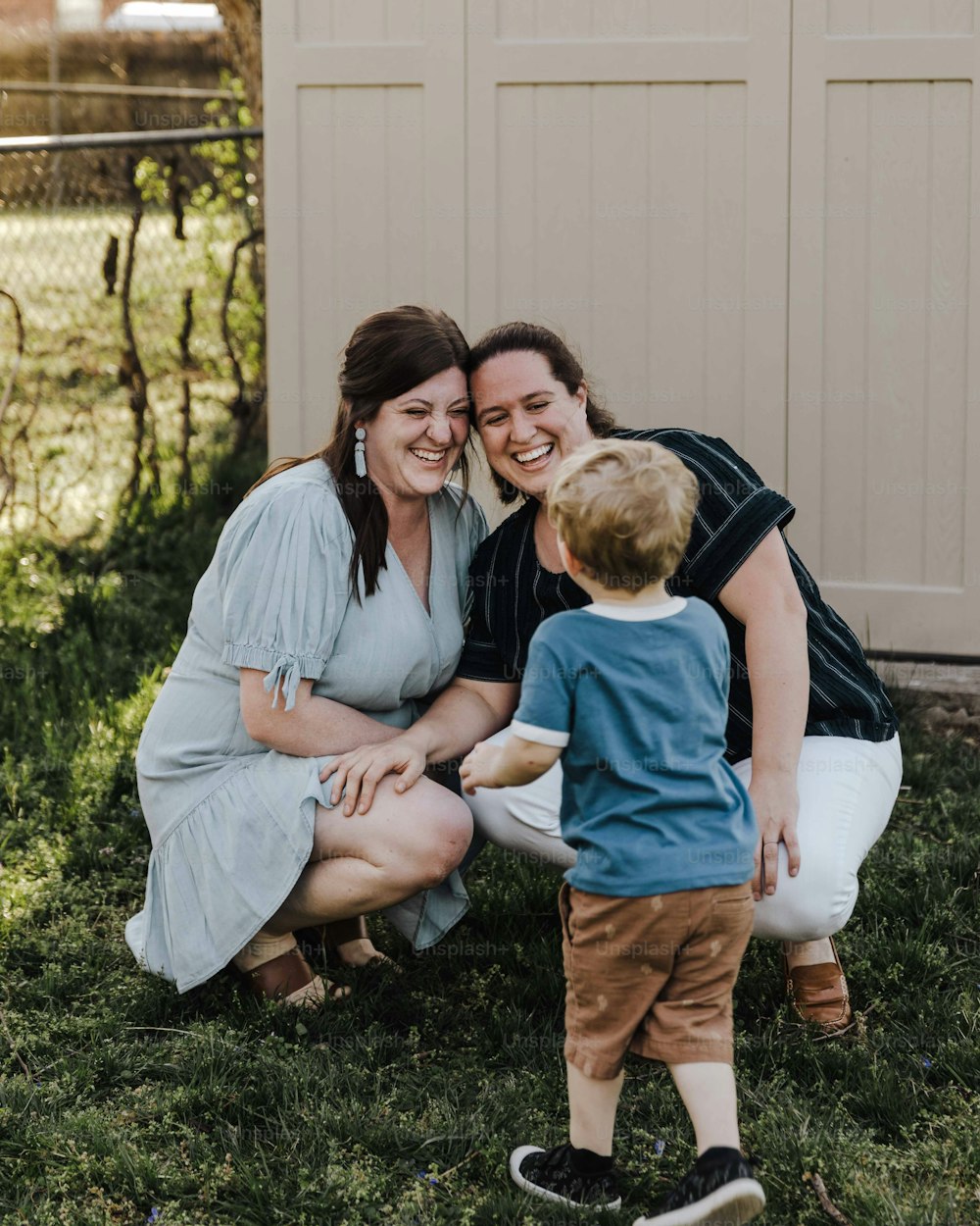 a woman and a boy are sitting in the grass