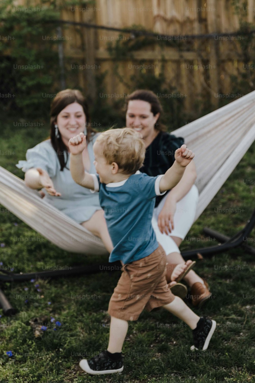a woman and a child playing in a hammock