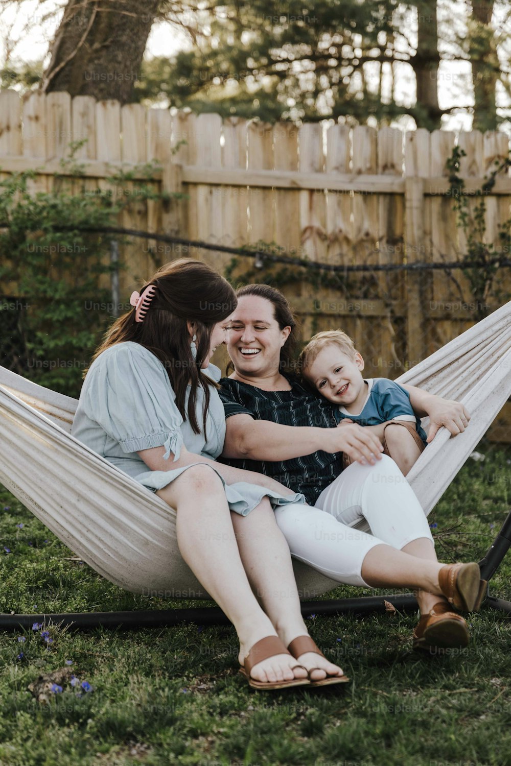 Una donna seduta su un'amaca con i suoi due figli