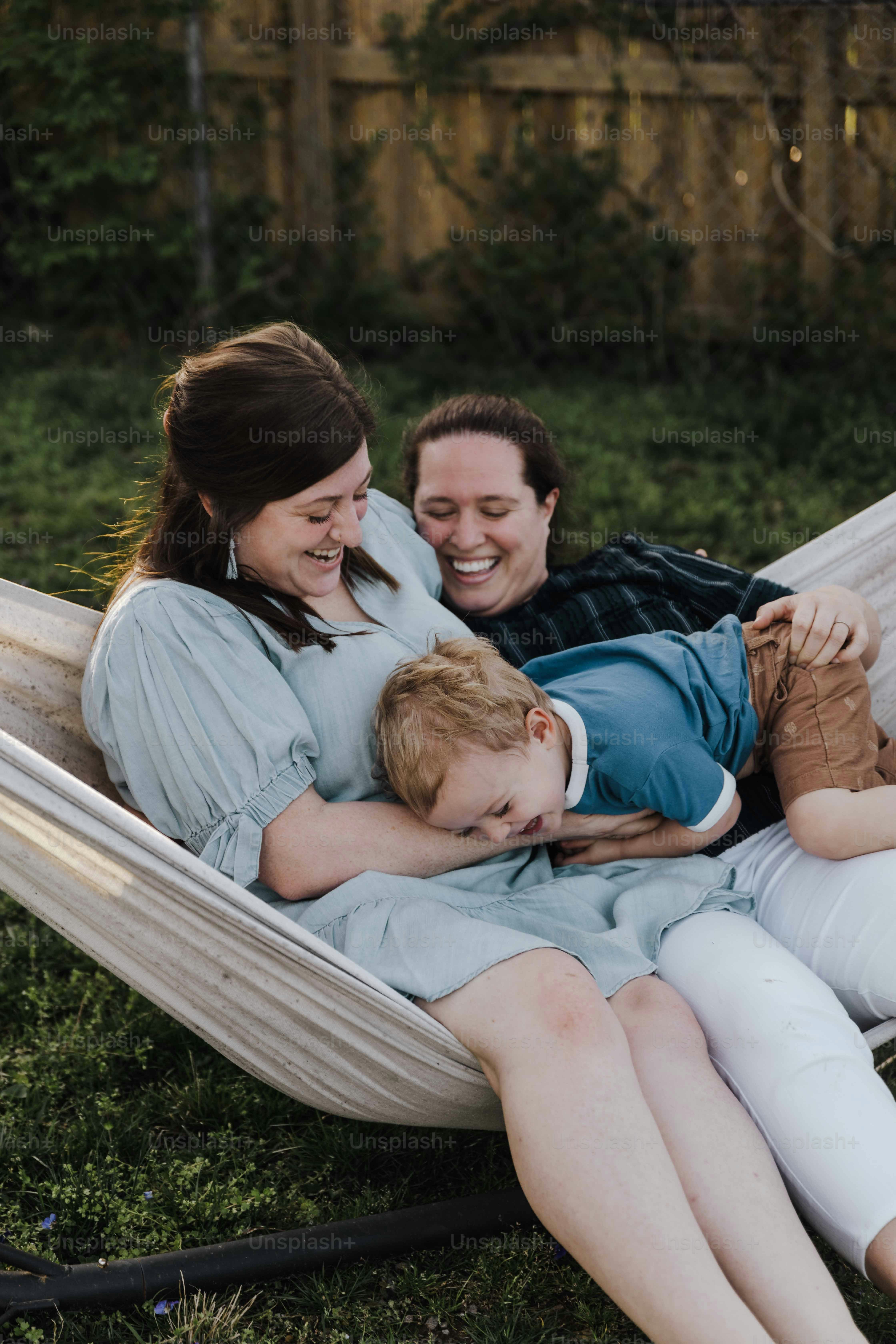 a woman and a boy laying in a hammock