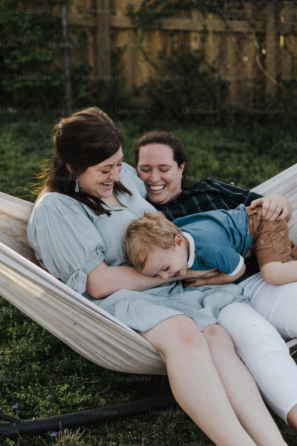 a woman and a boy laying in a hammock