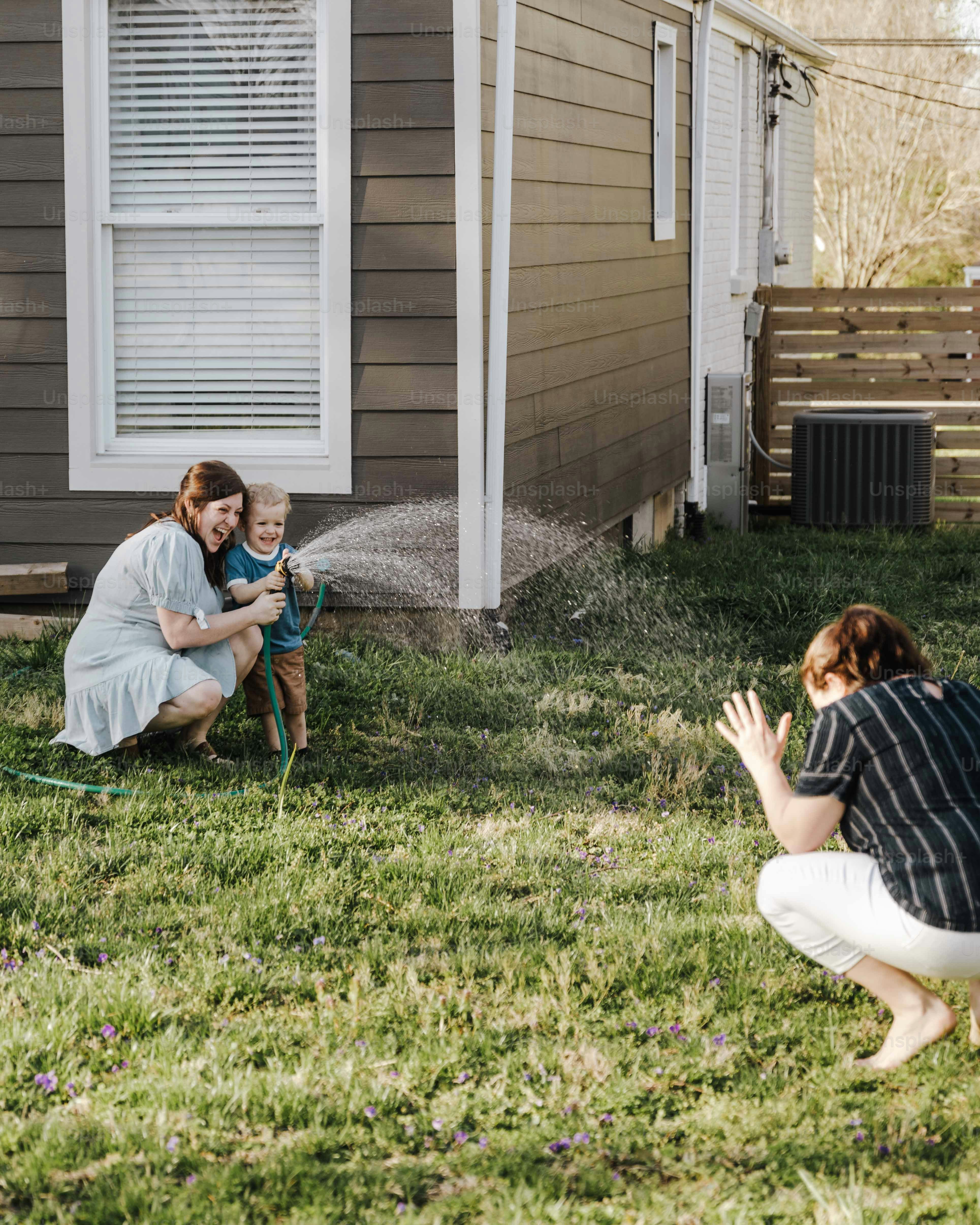 a woman kneeling down in the grass with a child