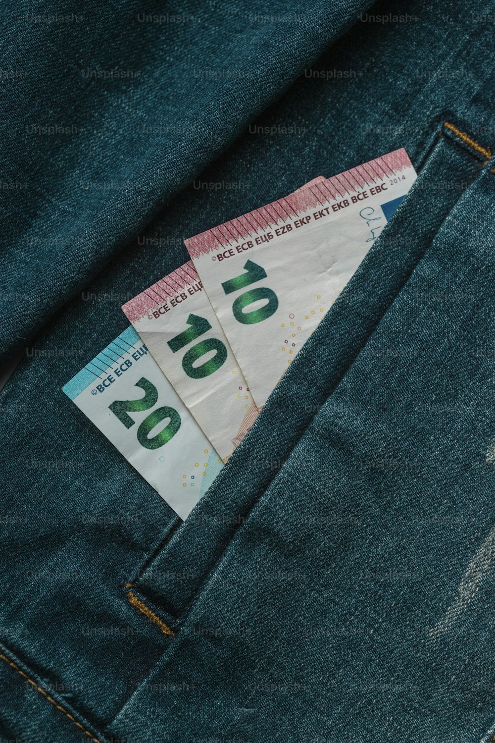 Un par de dinero que sobresale del bolsillo trasero de un par de jeans