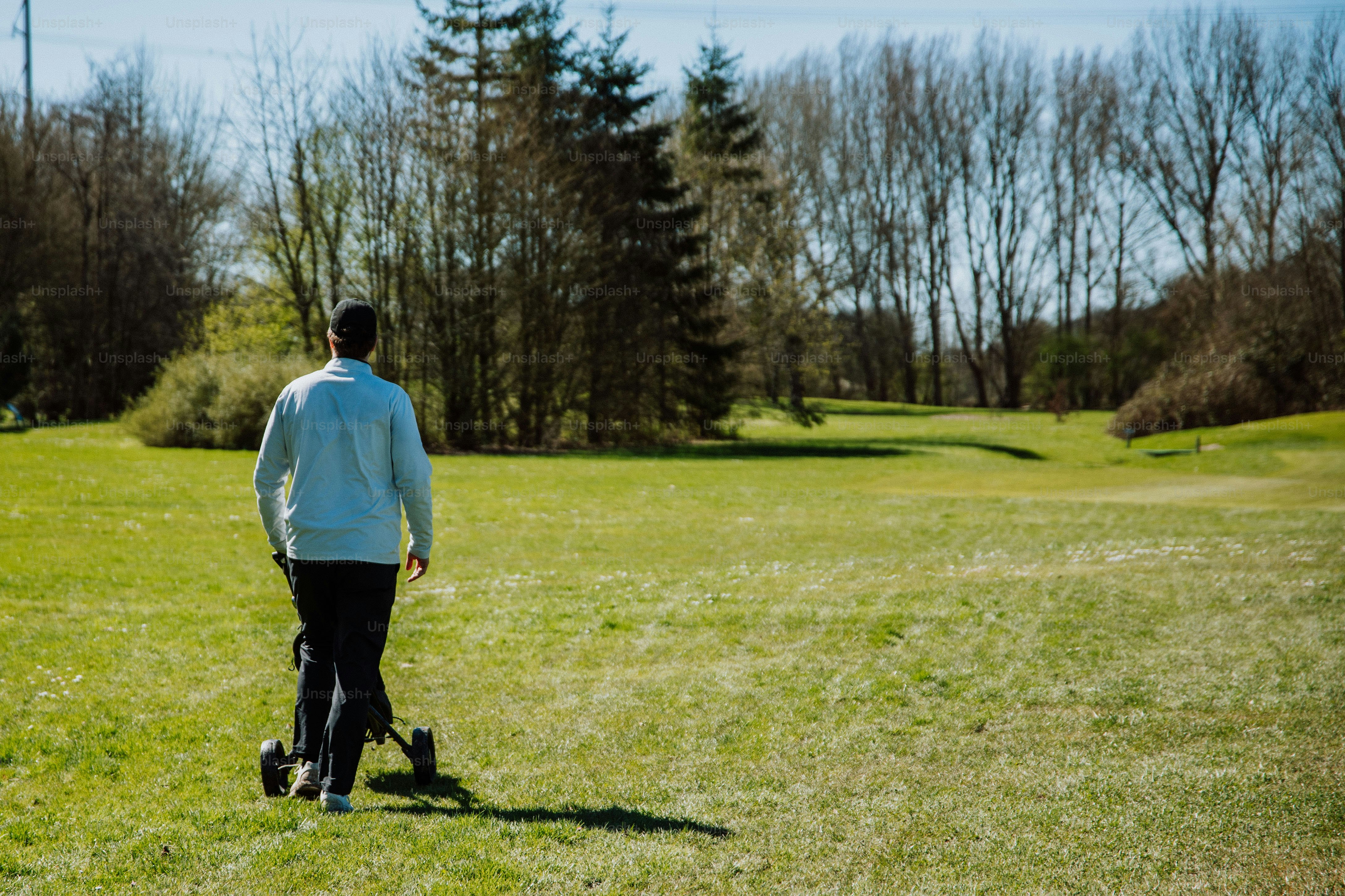 a man in a blue jacket is walking in a field