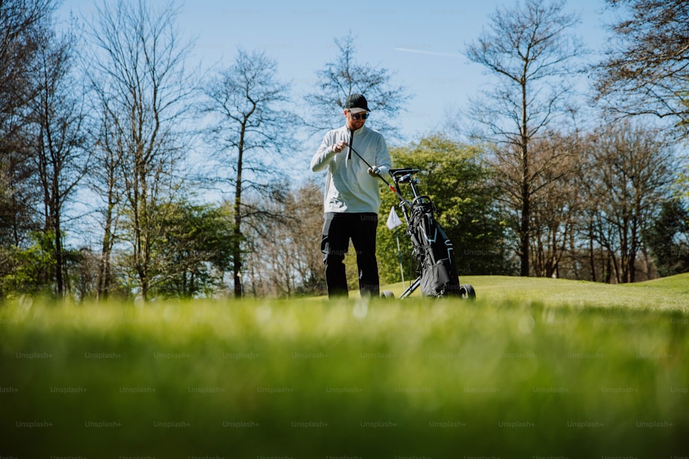 um homem segurando um taco de golfe em um campo de golfe