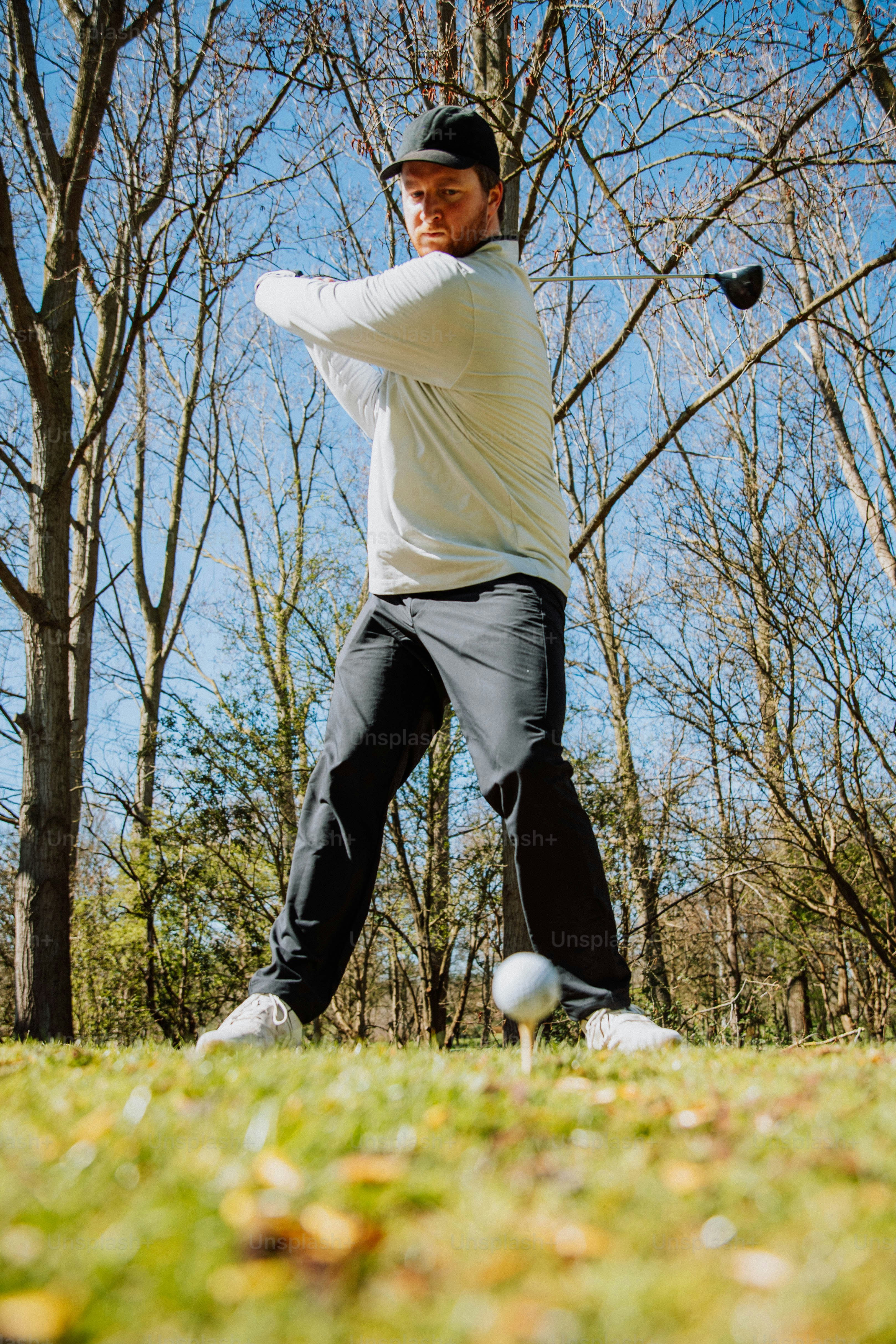 a man swinging a baseball bat at a ball