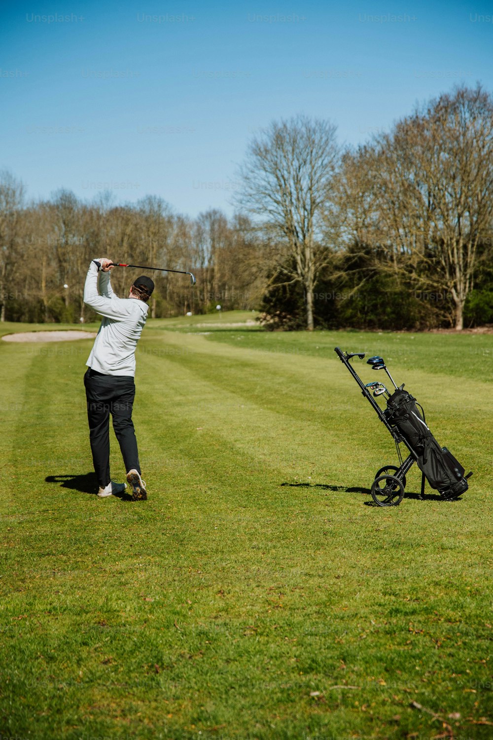 Un hombre balanceando un palo de golf en una pelota de golf