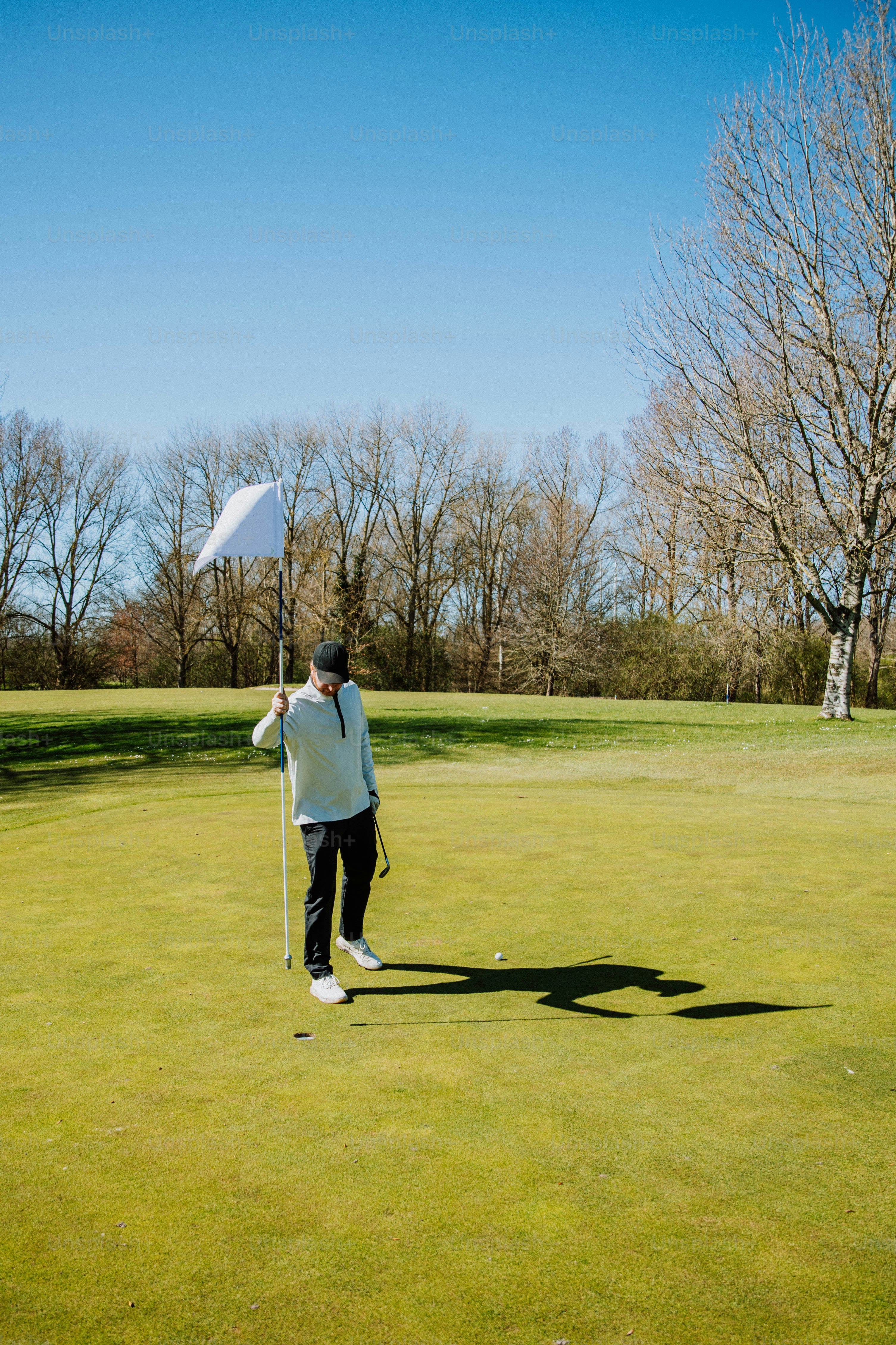 a man holding a white frisbee on top of a green field