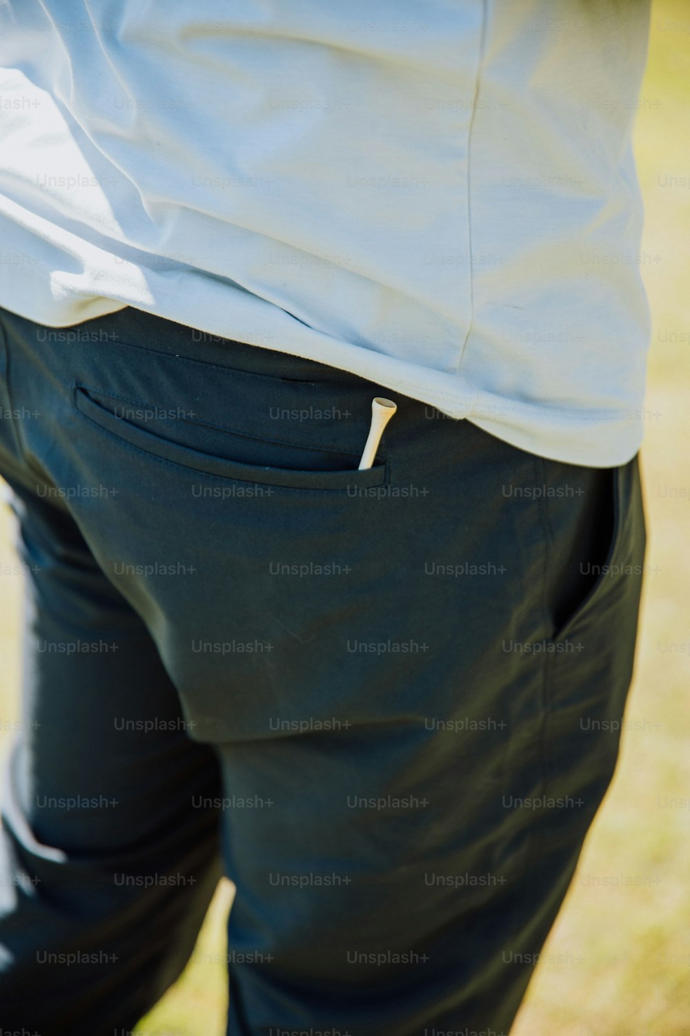 a close up of a person wearing a white shirt and black pants