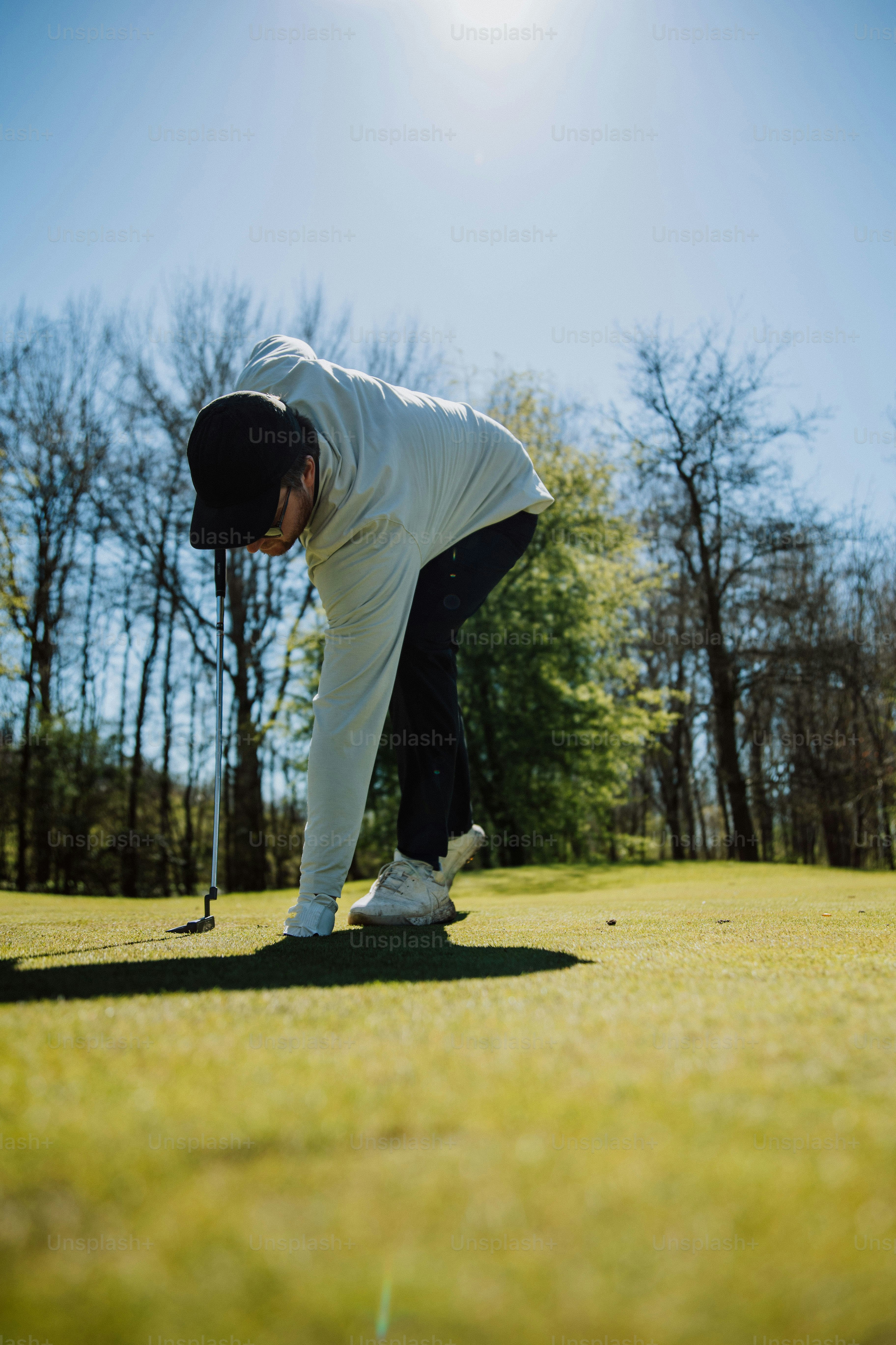 a man bending over to pick up a golf ball